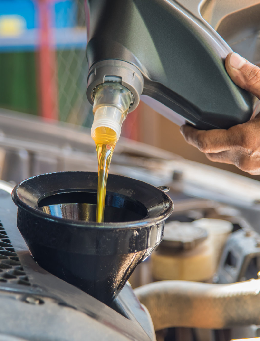 Mechanic filling up a vehicle with engine oil - MOT & Servicing Bristol